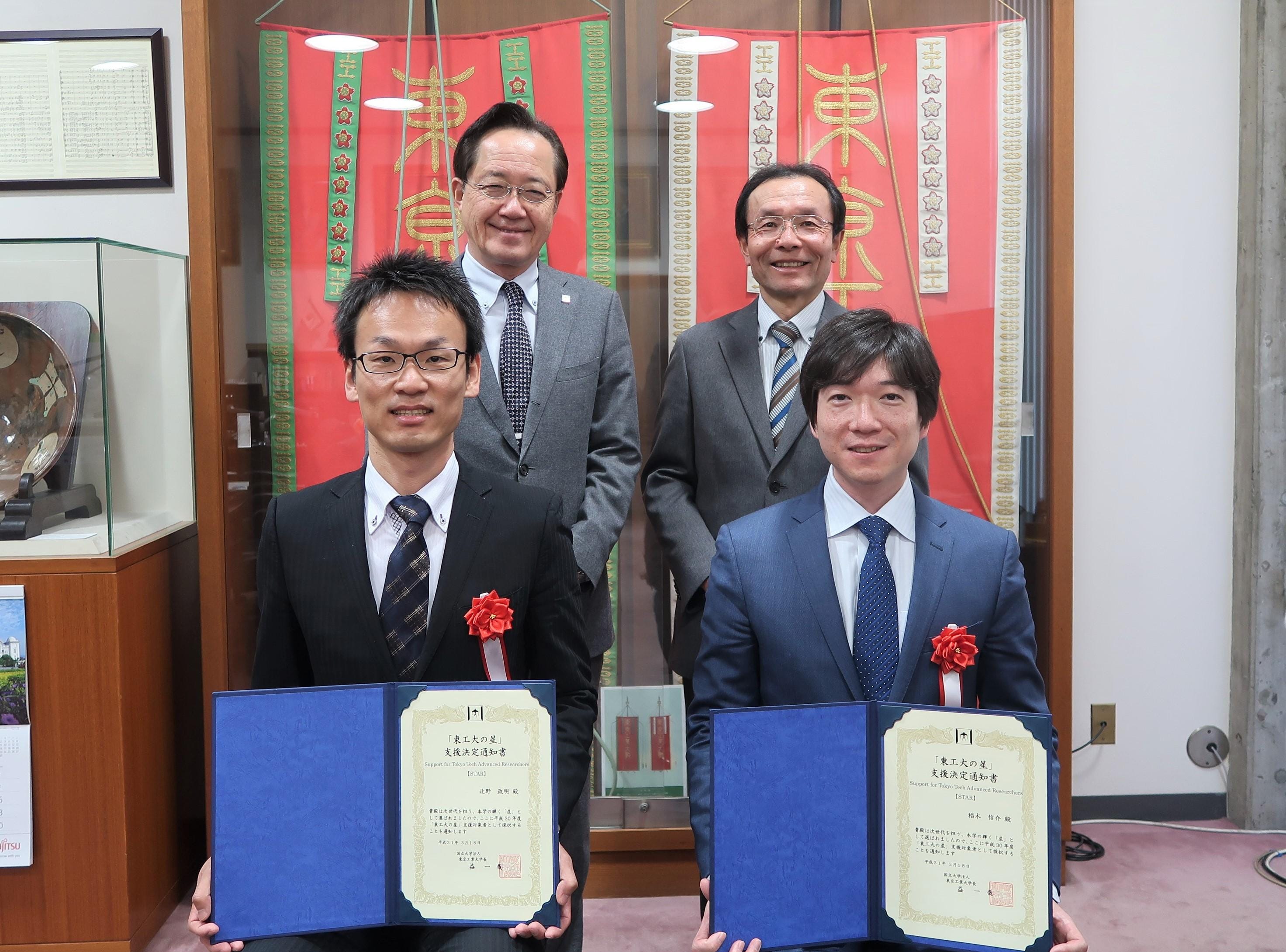 (後)益一哉学長、渡辺治理事・副学長(研究・産学連携本部長)、(前)北野政明准教授、稲木信介准教授